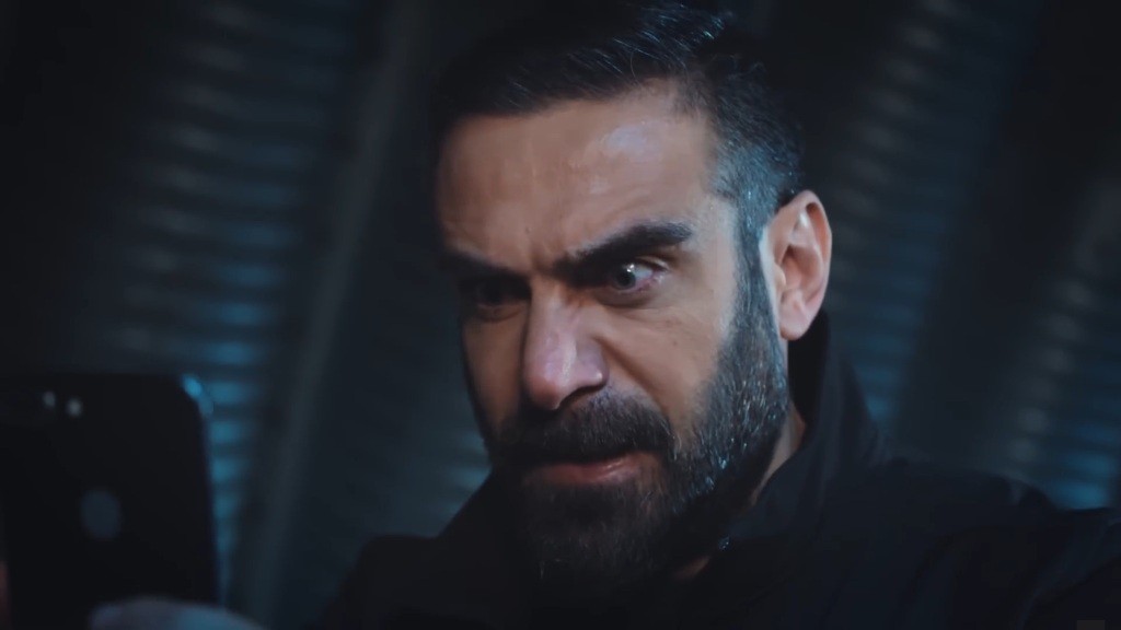 Trucizna z szaleństwem w oczach wpatruje się w swój telefon.