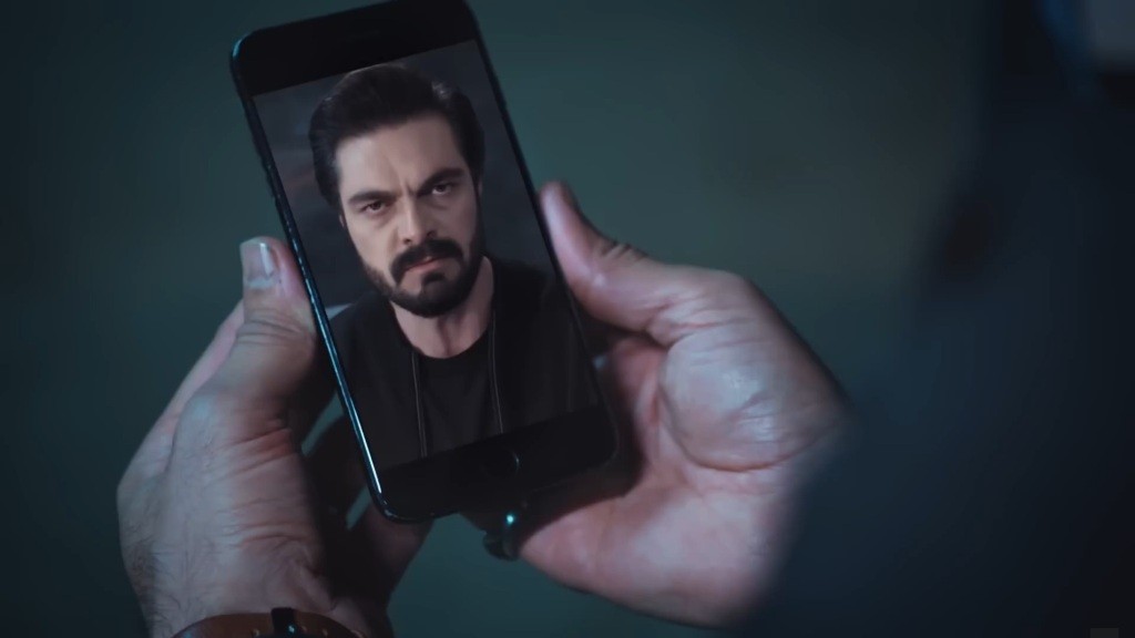 Twarz Yamana wyświetlona na telefonie Trucizny.