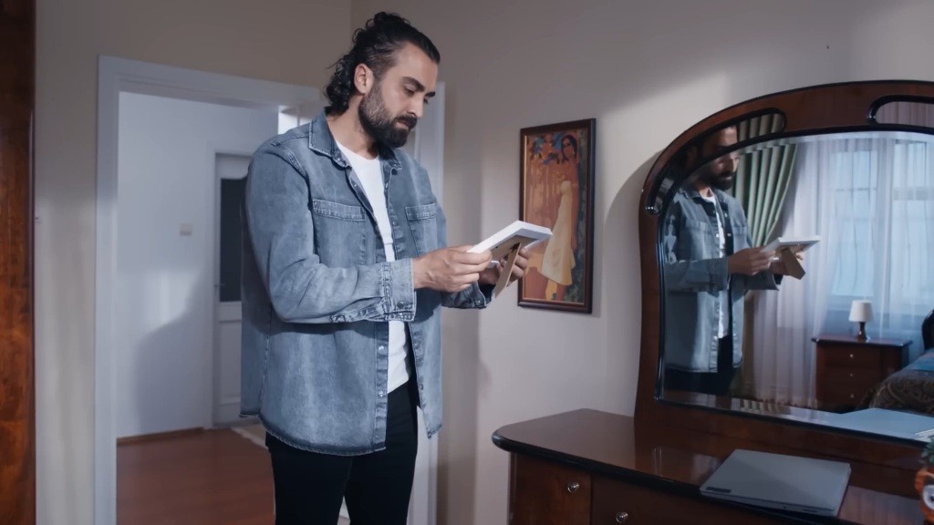 Ferit trzyma ramkę ze zdjęciem w domu Koraya.