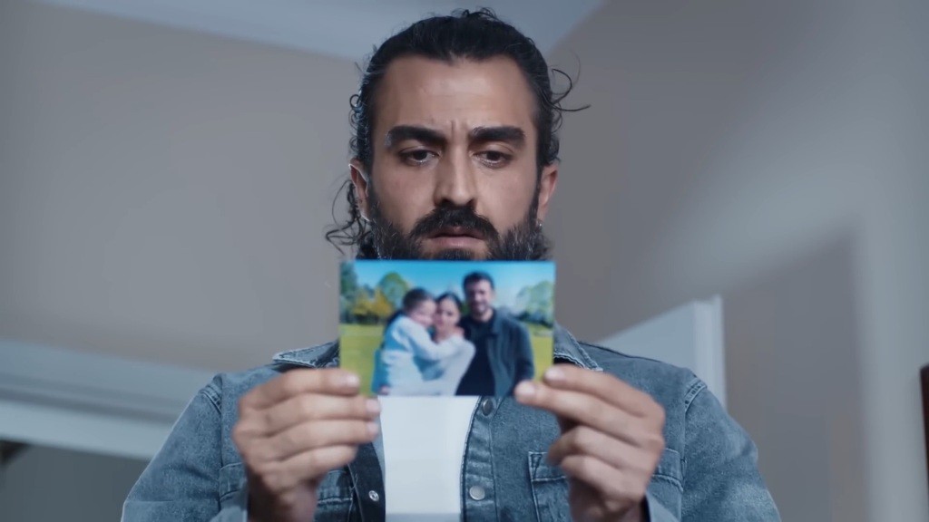 Ferit zapoznaje się z notatką na rewersie zdjęcia.