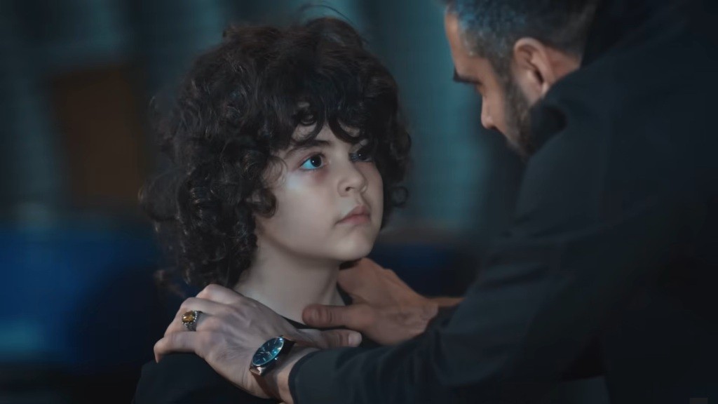 Trucizna trzyma dłonie na barkach Yusufa i patrzy mu głęboko w oczy.