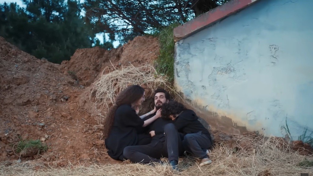 Yaman osuwa się na stertę piachu. Nana i Yusuf są przy nim.