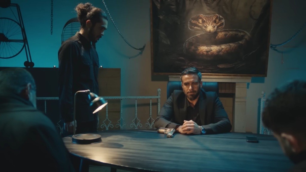 Trucizna siedzi w fotelu. Obok stoi jego człowiek.