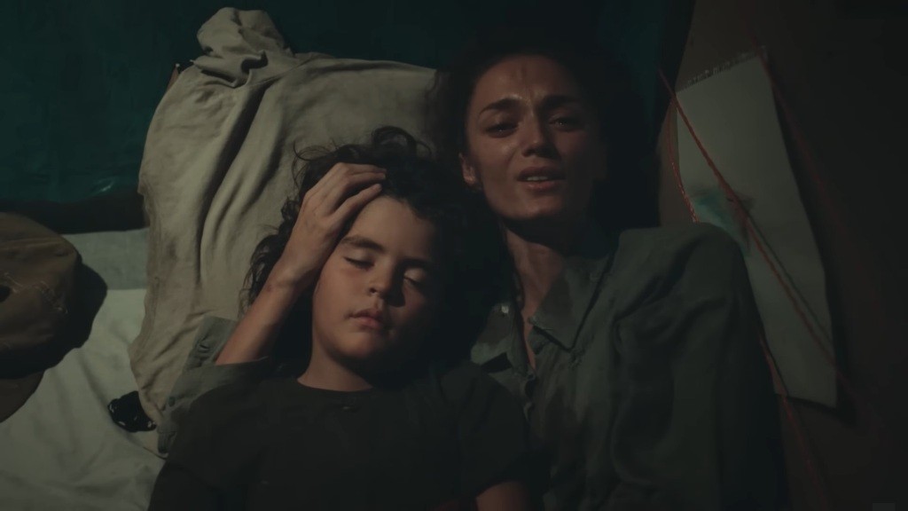 Yusuf śpi, a Nana obejmuje jego głowę.