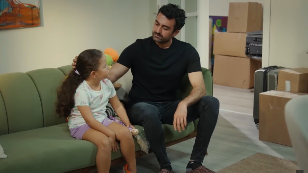 Ferit siedzi obok Dogi i głaszcze ją po włosach.