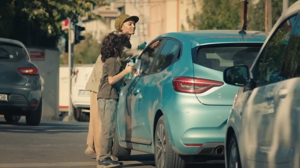 Nana i Yusuf myją szybę samochodu.