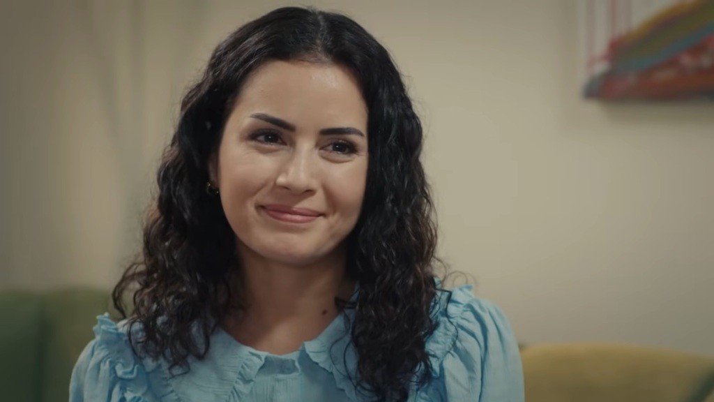 Aynur uśmiecha się promiennie.