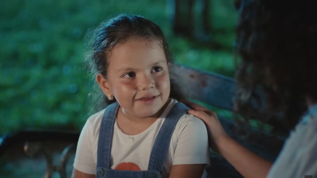 Doga na ławce w parku. Aynur trzyma rękę na jej barku.