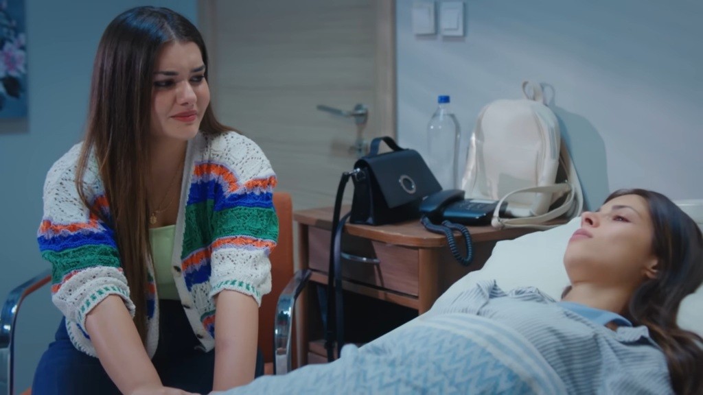 Ayse jest w szpitalu. Leży na łóżku, a obok niej siedzi Nese, trzymając jej rękę.