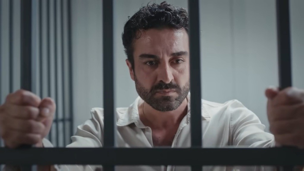 Ferit zaciska dłonie na kratach.