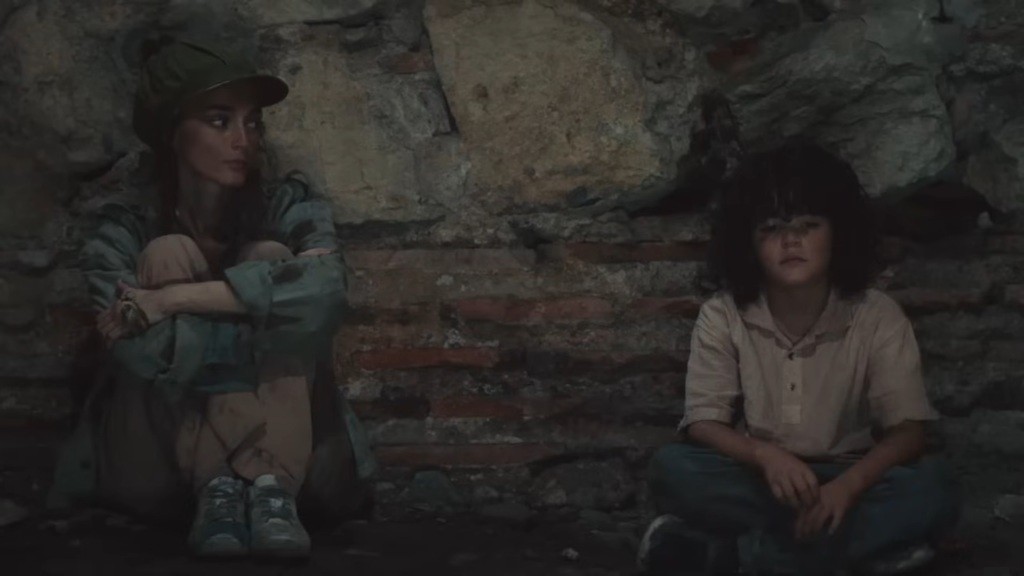 Nana i Yusuf siedzą pod kamiennym murem, oddaleni od siebie.