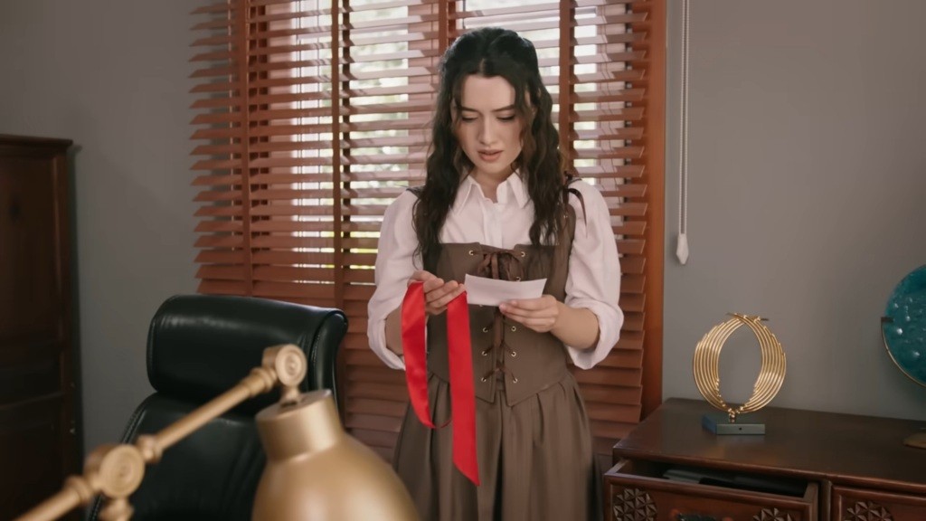 Zeynep trzyma w rękach wstążkę i rysunek Halila.
