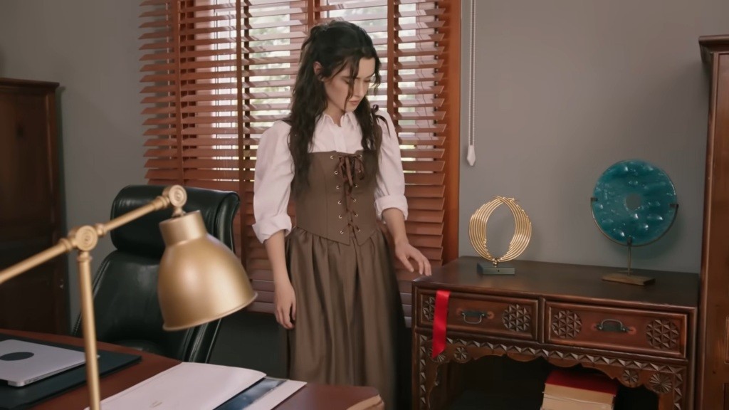 Zeynep zauważa czerwoną wstążkę wystającą z szuflady.
