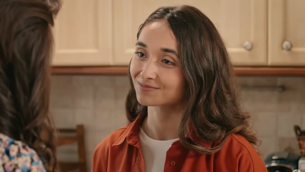 Ozlem uśmiecha się, rozmawiając z Ferihą.