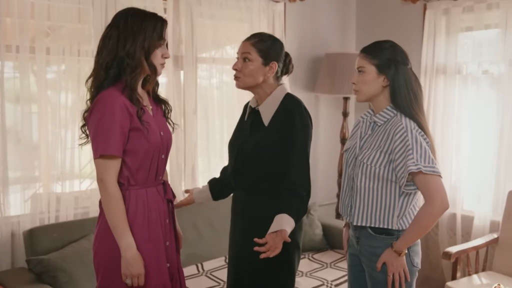 Tulay rozkłada ręce, stojąc przed Zeynep. Merve stoi tuż za mamą.