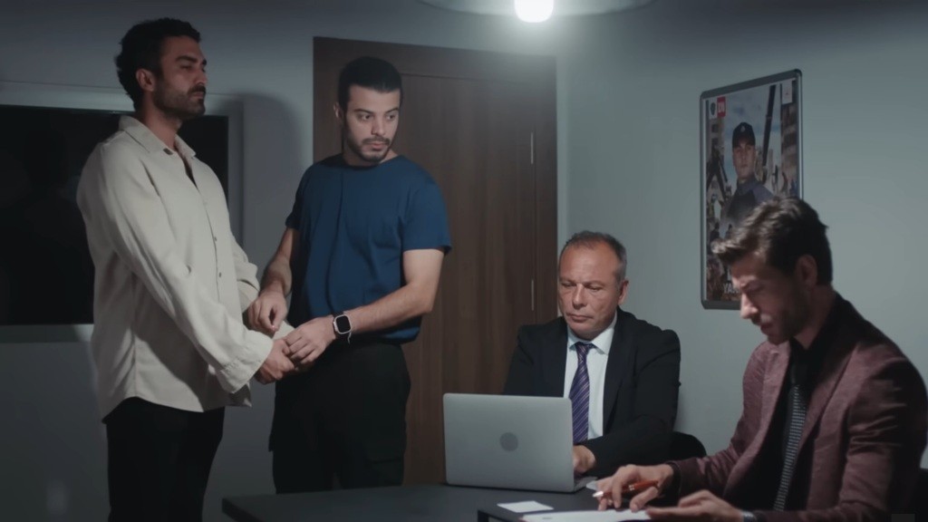 Volkan wprowadza Ferita do pokoju przesłuchań.