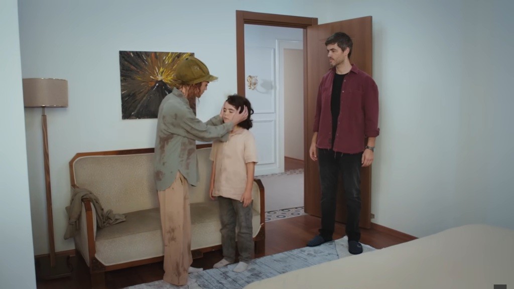 Nana obejmuje dłońmi głowę Yusufa. Obok stoi Poyraz.