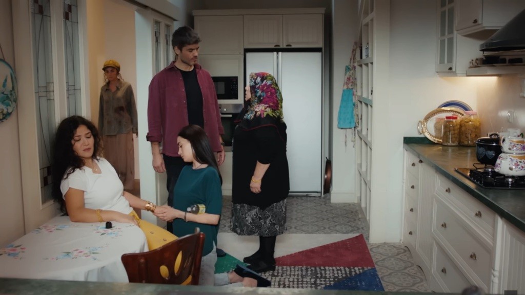 Poyraz rozmawia w kuchni z matką. Nazli klęczy przed siedzącą na krześle Cansel i masuje jej nadgarstki. Nana przysłuchuje się ich rozmowie, stojąc na korytarzu.