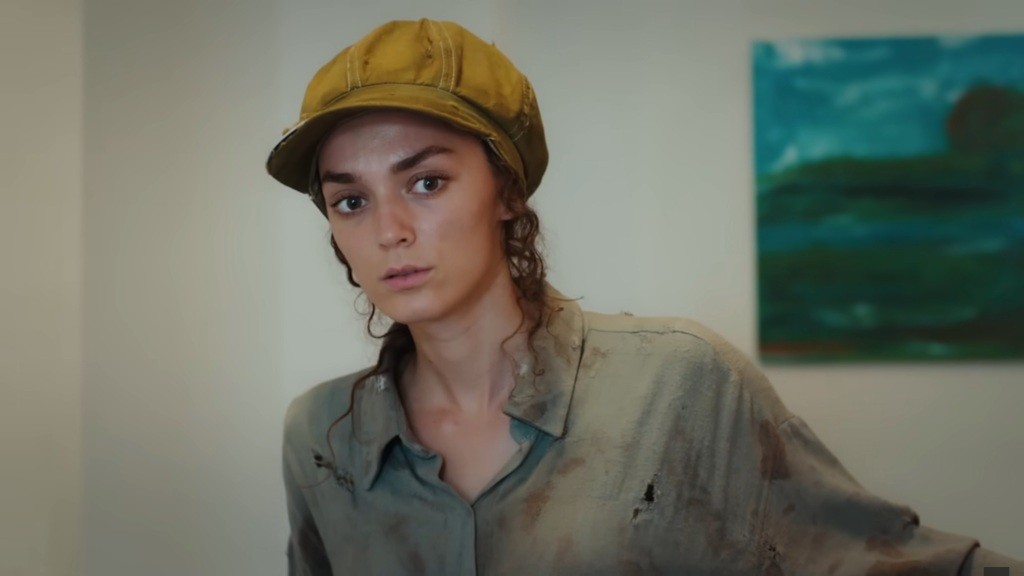 Zbliżenie na Nanę podsłuchującą rozmowę w kuchni.