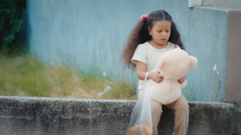 Doga siedzi na murku. Smutnym wzrokiem patrzy na swojego pluszaka.