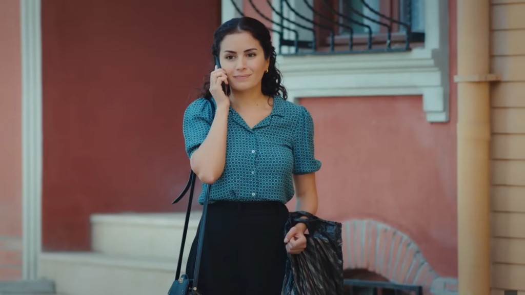 Aynur rozmawia przez telefon, znajdując się przed domem prokuratora.