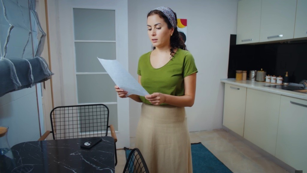 Aynur zapoznaje się z listą instrukcji od właściciela domu.