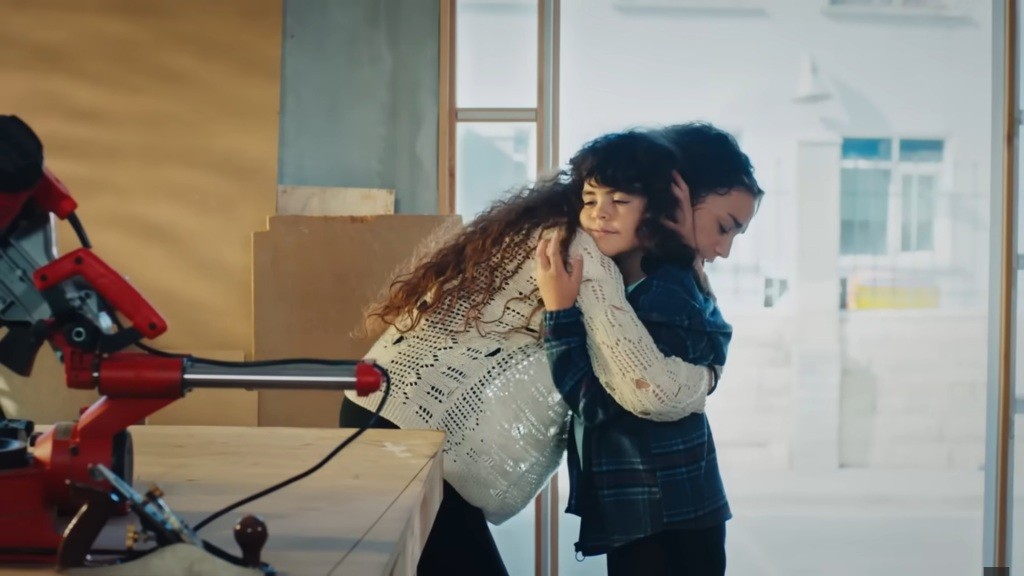 Nana przytula Yusufa w warsztacie stolarskim.