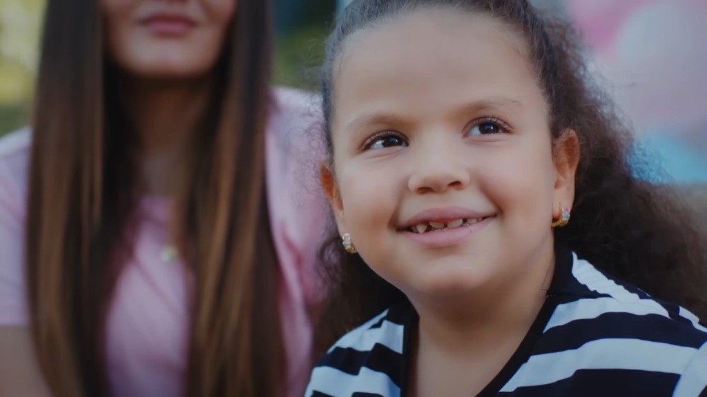 Doga uśmiecha się, widząc tańczących rodziców.