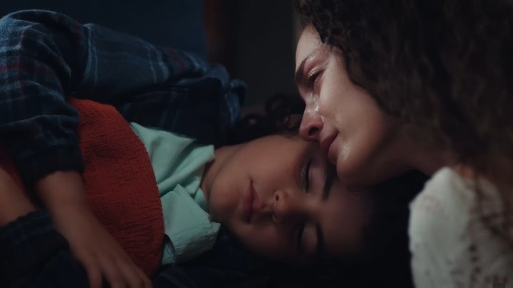 Nana przytula twarz do głowy śpiącego Yusufa.
