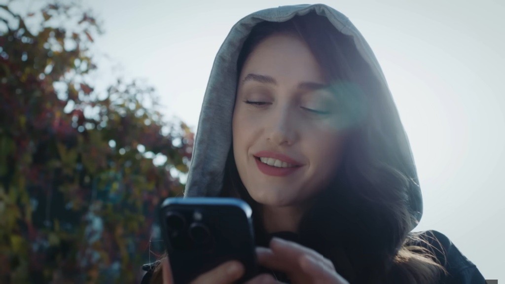 Derya wpatruje się w ekran telefonu.