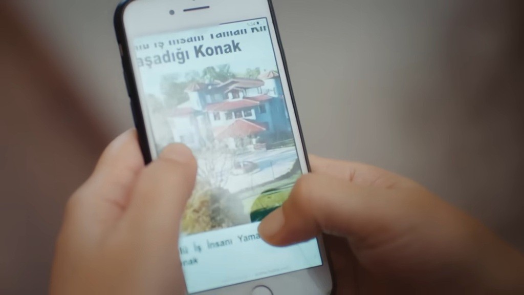 Na ekranie telefonu wyświetlone jest zdjęcie rezydencji Kirimlich.