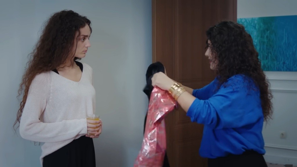 Cansel wręcza Nanie sukienkę w prezencie.