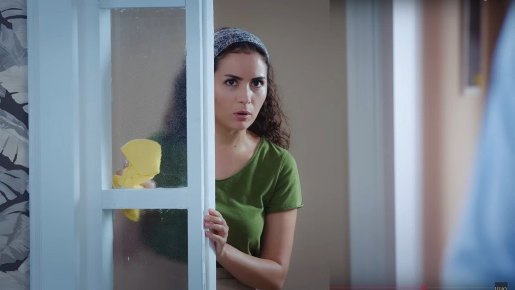 Aynur myje przeszklone drzwi.