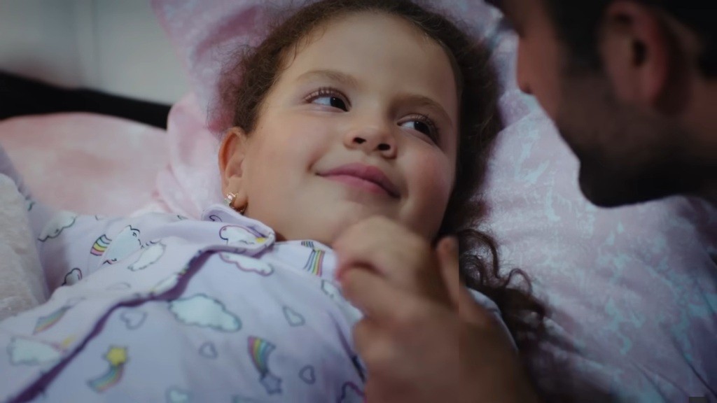 Doga uśmiecha się, patrząc na ojca.