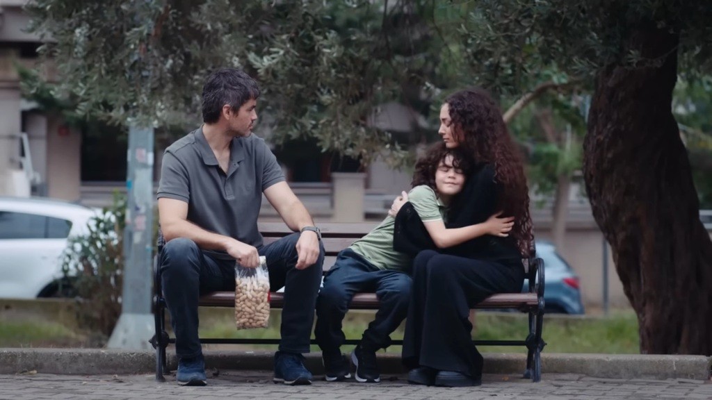 Yusuf przytula Nanę, a obok nich siedzi Poyraz, trzymając w ręku paczkę fistaszków.