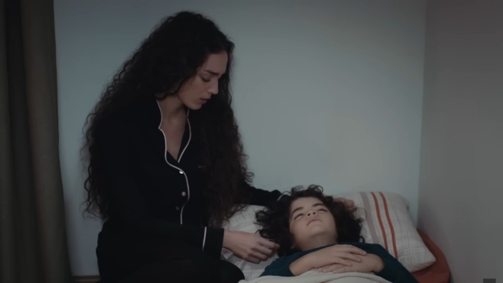 Nana kuca przy posłaniu, na którym śpi Yusuf.