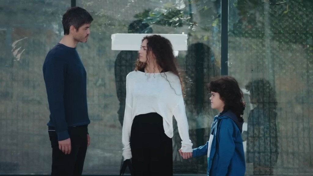 Nana trzyma Yusufa za rękę, patrząc na Poyraza.