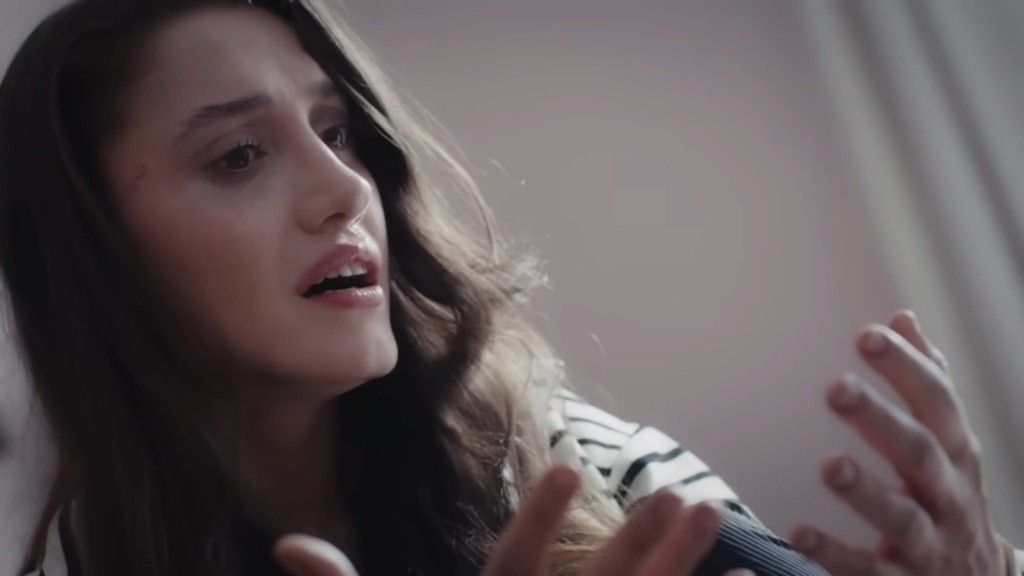 Derya patrzy na swoje dłonie.