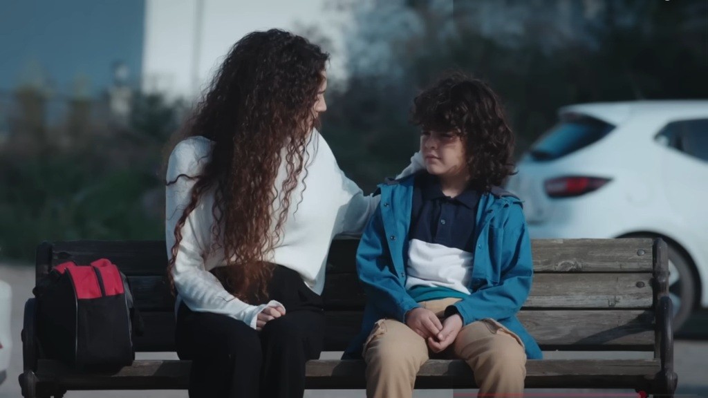 Yusuf i Nana siedzą na ławce.