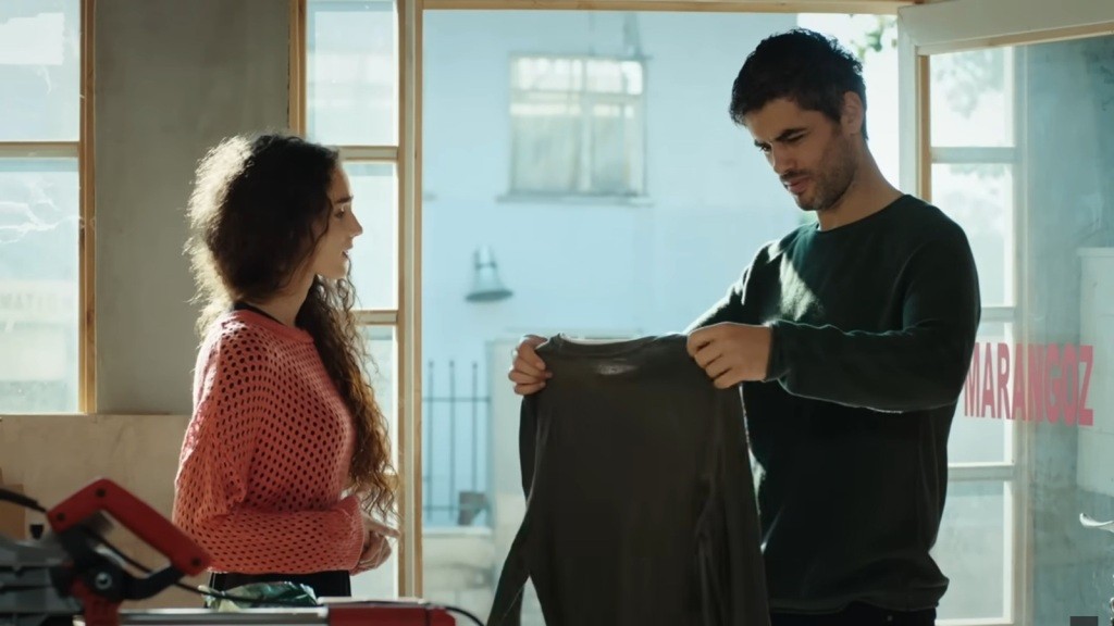 Poyraz ogląda sweter, który jest prezentem od Nany.