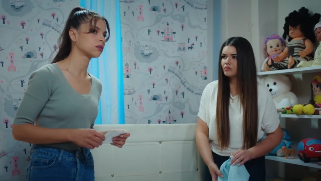 Ayse i jej siostra w pokoju Dogi. Ayse trzyma w rękach zdjęcie.