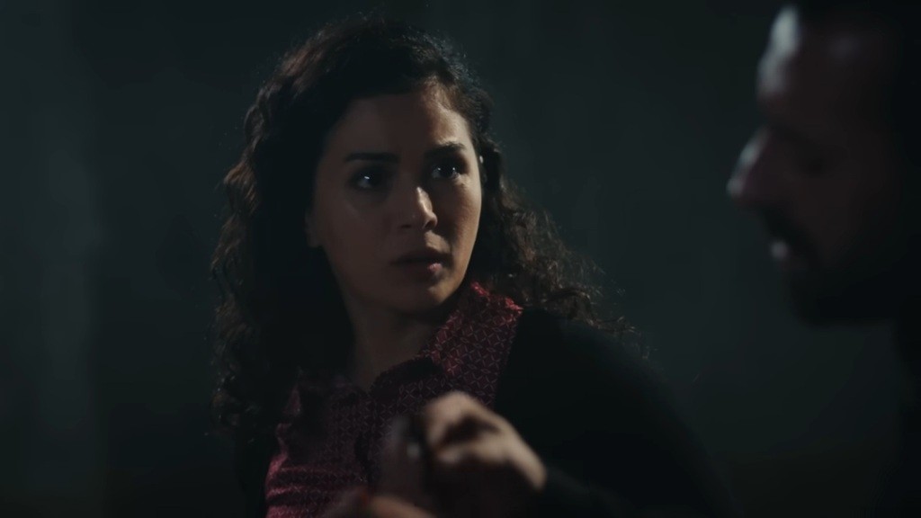 Zbliżenie na twarz przerażonej Aynur. Patrzy na swojego porywacza.