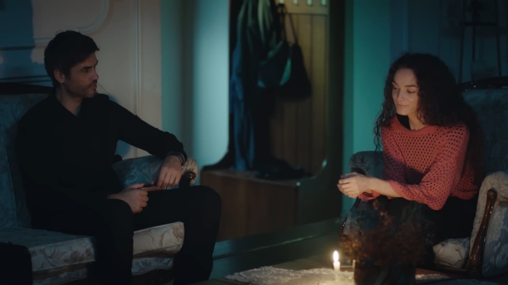 Poyraz i Nana rozmawiają w blasku świecy.