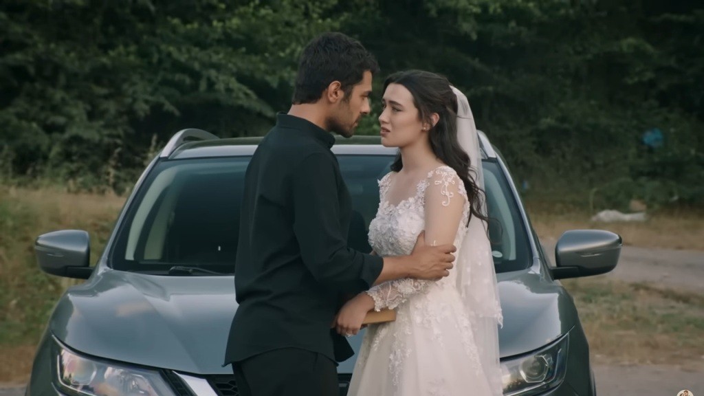 Halil i Zeynep stoją przy samochodzie.