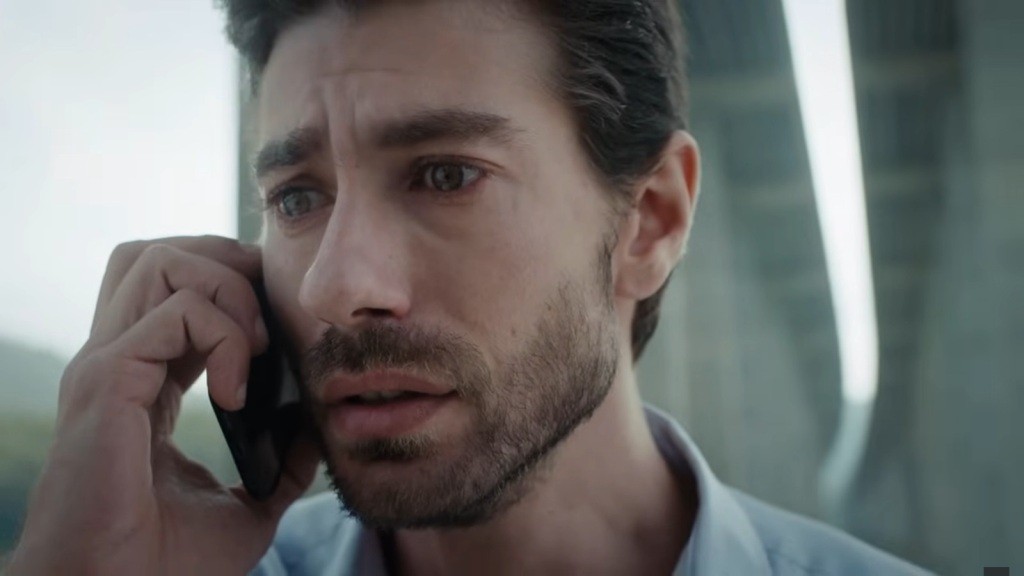 Sinan trzyma telefon przy uchu, a jego twarz zdradza zdruzgotanie i przerażenie.