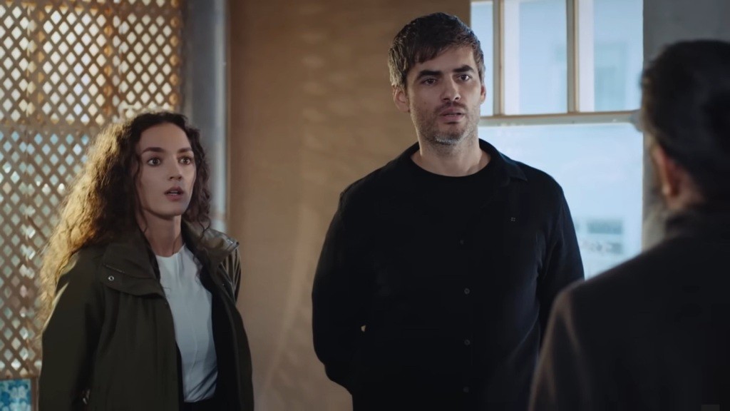 Na twarzy Nany maluje się zaskoczenie. Obok niej stoi Poyraz. Oboje chowają ręce za plecami.