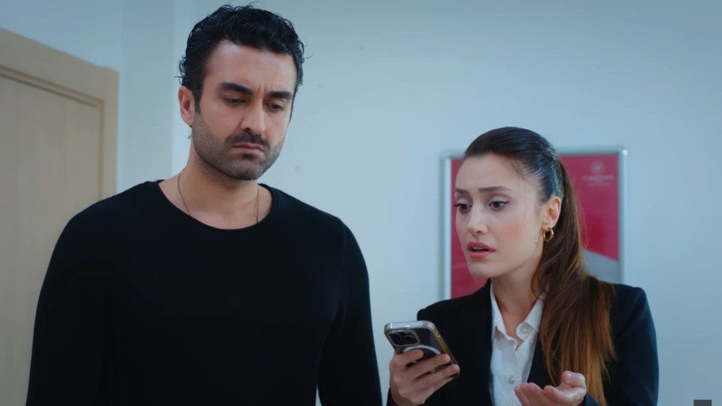 Ferit i Derya stoją w sali szpitalnej. Derya trzyma telefon w ręce, z niepokojem spoglądając na ekran.