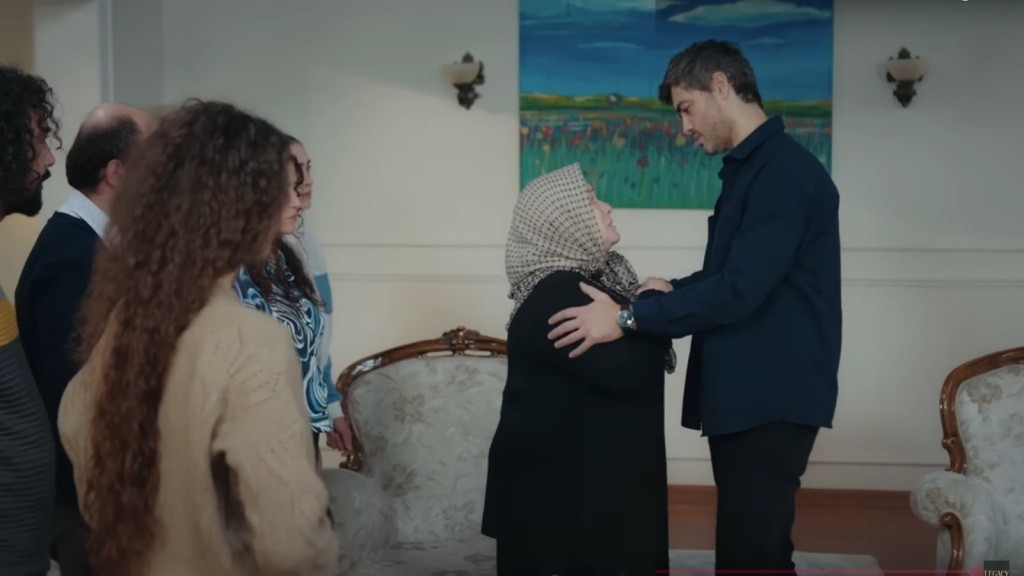 Poyraz obejmuje ramiona matki, patrząc jej w oczy.