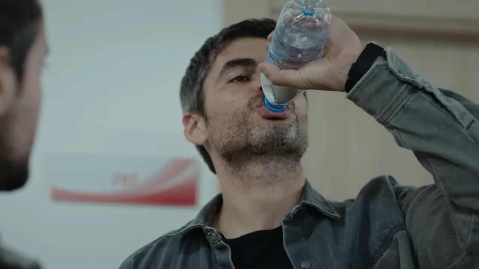 Poyraz przechyla butelkę z wodą z taką intensywnością, jakby był na skraju wyczerpania z pragnienia.
