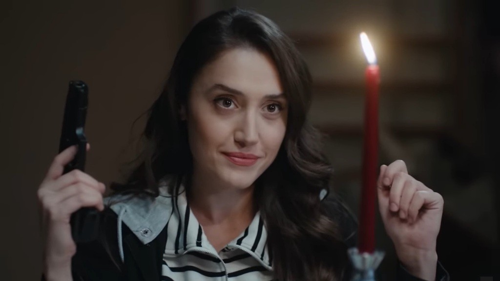 Derya trzyma pistolet w ręku. Obok pali się świeca, tworząc pozornie romantyczny nastrój.